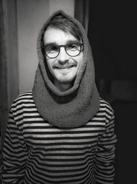 Portrait of young man wearing eyeglasses while standing at home