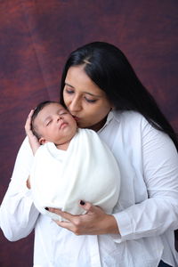 High angle view of mother and daughter lying on bed at home