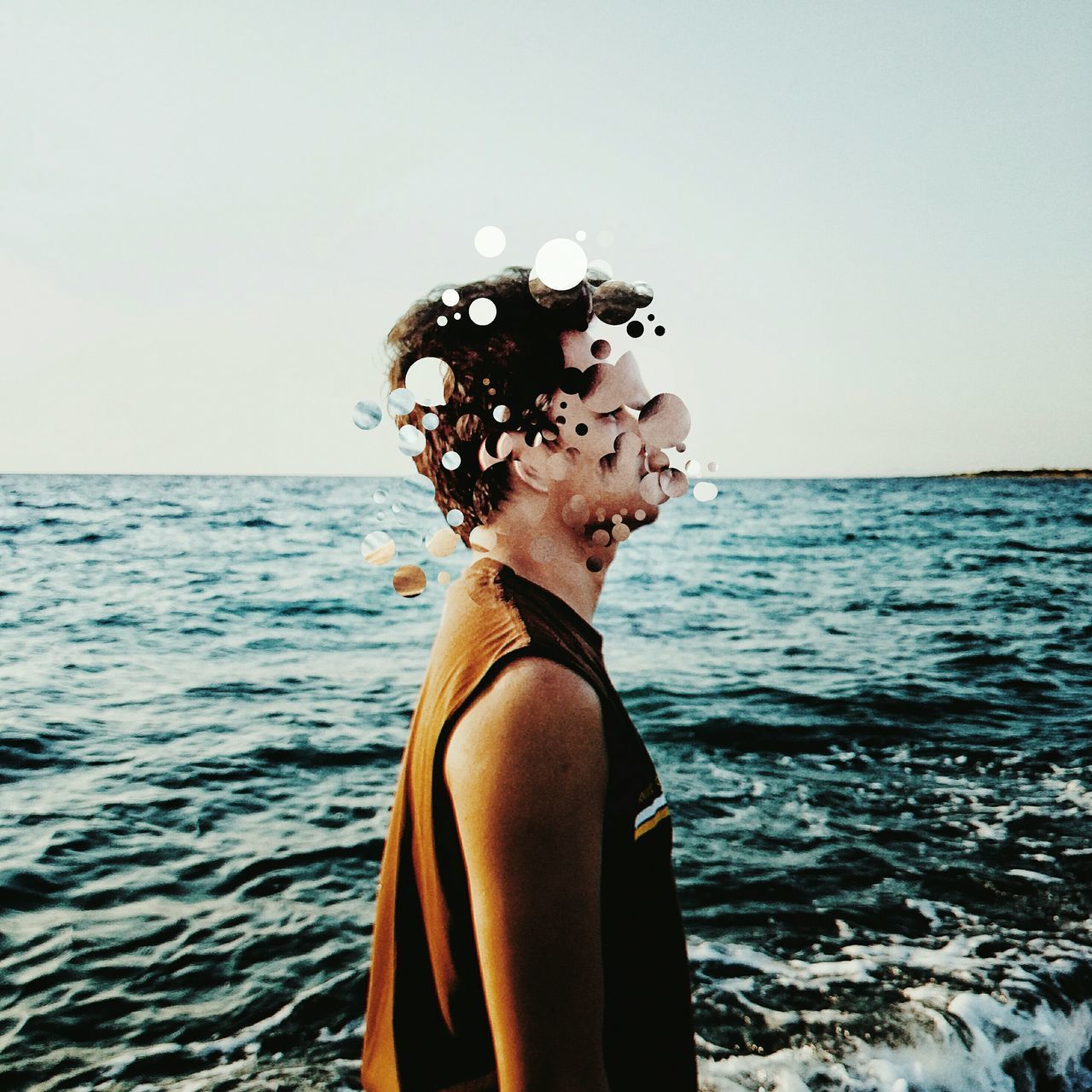 SIDE VIEW OF WOMAN STANDING IN SEA AGAINST CLEAR SKY