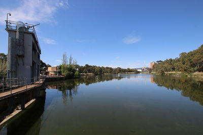 Scenic view of lake by buildings against sky