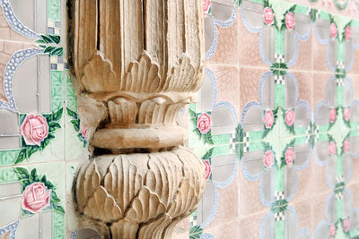 Close-up of old column on tiled wall