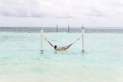 Person on sea against sky