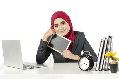 Portrait of young woman using smart phone against white background