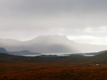 Scenic view of mountains against cloudy sky