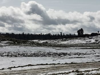 Scenic view of snow covered land against sky