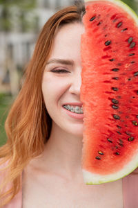 Close-up of young woman holding fruit