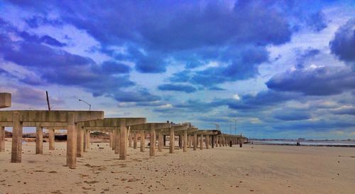 Scenic view of beach against cloudy sky