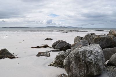 Rocks on beach against sky