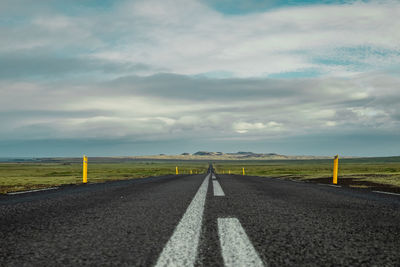 Road amidst field against sky