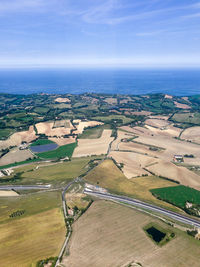 High angle view of sea by landscape against sky