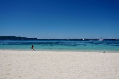 Scenic view of beach against clear blue sky