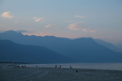 Scenic view of sea and mountains against sky during sunset