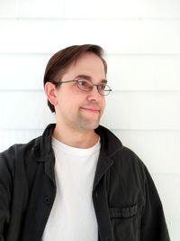 Portrait of young man standing against wall