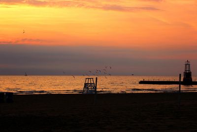 Pier on sea at sunset