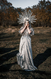 Portrait of woman standing against tree