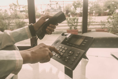 Midsection of woman using telephone on table