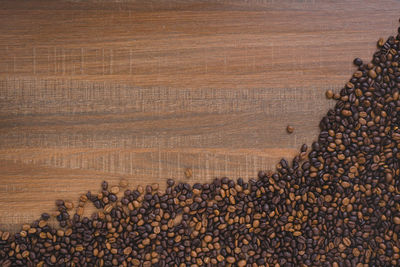 Directly above shot of roasted coffee beans on wooden table
