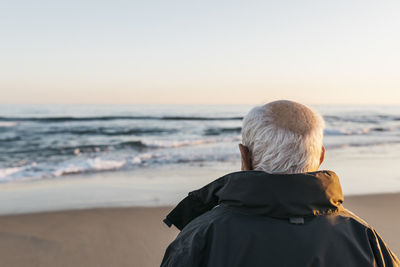 Senior man looking at the sea, rear view