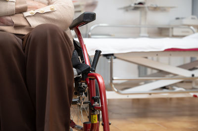 Rear view of man sitting on wheelchair in factory