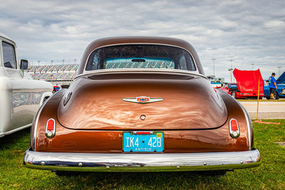 Vintage car parked on land against sky