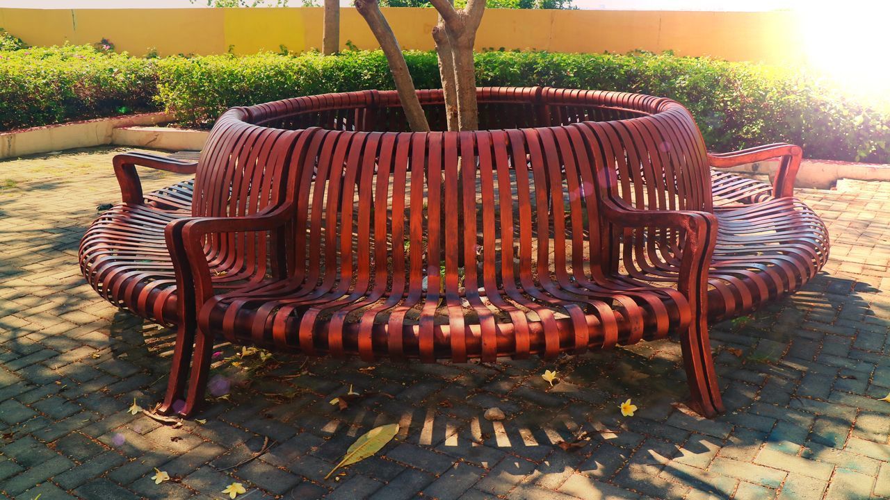 EMPTY BENCH IN PARK AGAINST TREES