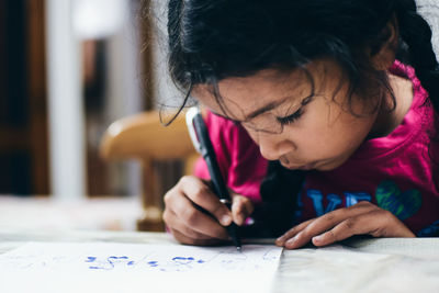 Close-up of girl drawing on table