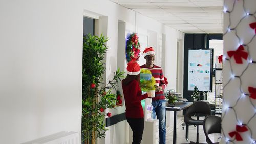 Rear view of woman holding christmas tree