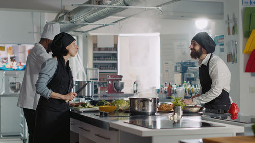 Chef and trainee working in kitchen