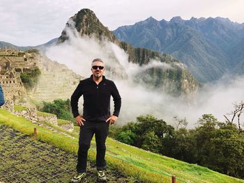 Full length portrait of young man standing on mountain