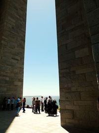 People at historic building against sky