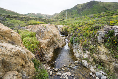 Scenic view of river amidst mountains against sky