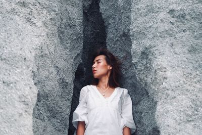 Portrait of woman standing against wall