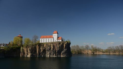 Lighthouse by lake against sky