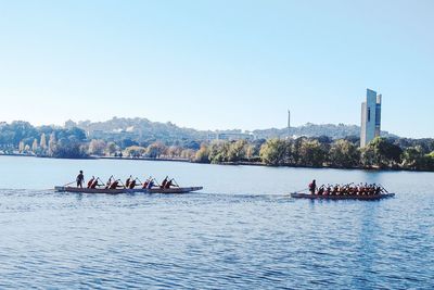 People rowing boats in river