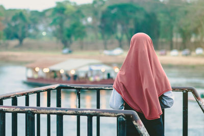 Rear view of man standing by railing