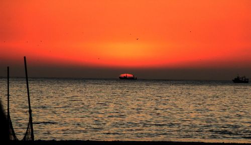 Scenic view of sea against orange sky