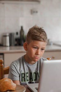 Portrait of boy using mobile phone at home