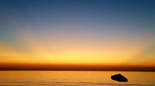 Scenic view of sea against orange sky