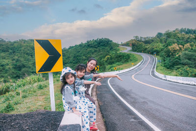 My wife with daughter with raised arm on road look like number 3