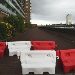 Red garbage bin against buildings in city