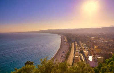 High angle view of buildings and sea against sky during sunset