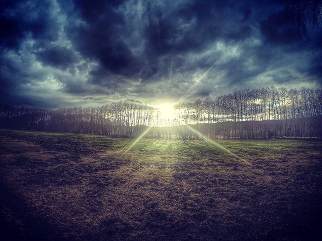 sky, cloud - sky, sun, field, tranquility, cloudy, sunbeam, tranquil scene, landscape, nature, scenics, sunlight, weather, grass, beauty in nature, lens flare, sunset, fence, idyllic, cloud