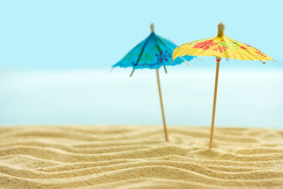 Close-up of umbrella on beach against sky