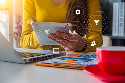 Midsection of man using laptop on table