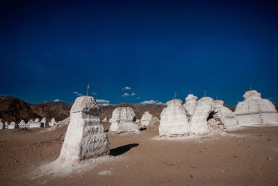 Panoramic view of rock formations against blue sky