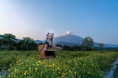 Scenic view of flowering plants on field against sky