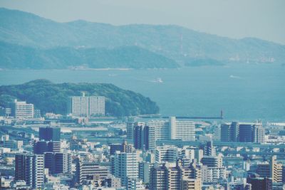 High angle view of buildings by sea against sky