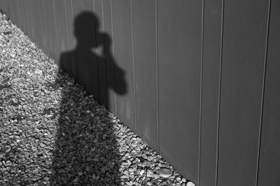 High angle view of shadow on footpath by wall
