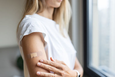 Midsection of woman with bandage on hand