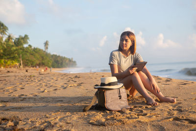 Young woman sitting on beach